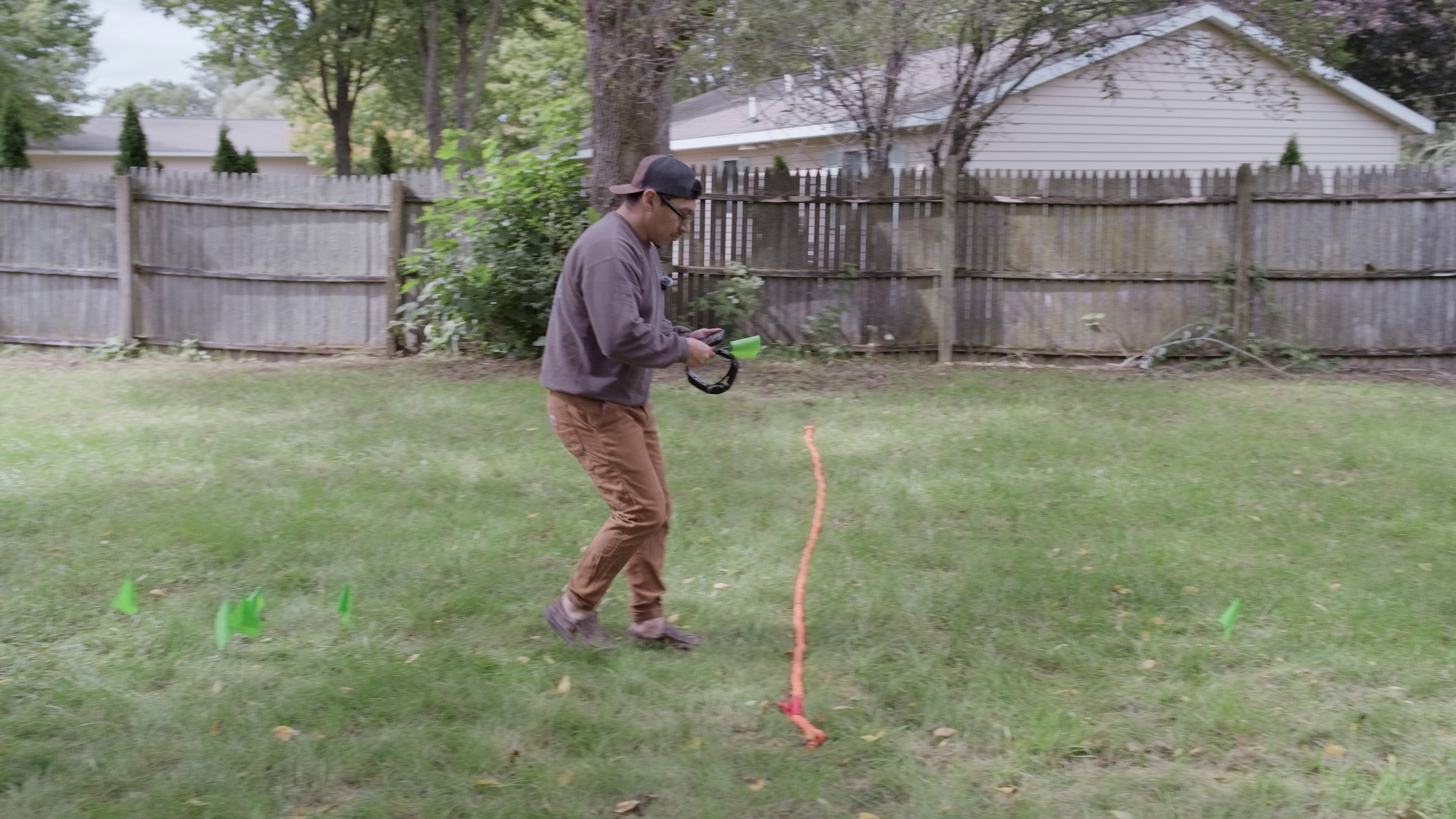 Lucas walking toward the rope boundary with SpotOn collar in hand during independent testing