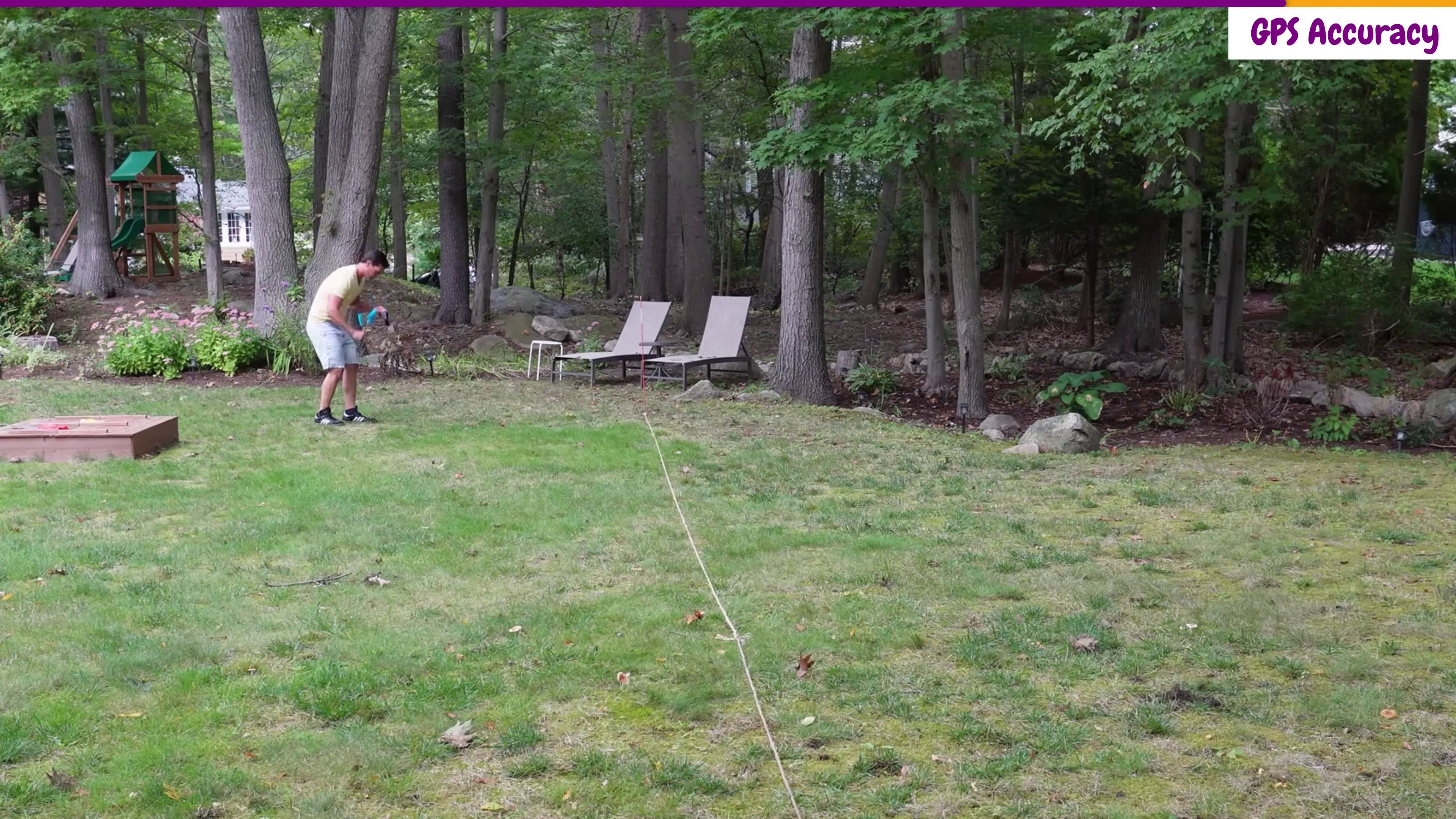 Zach Lovatt testing SpotOn Nova GPS fence accuracy by walking the collar across a boundary rope under partial tree cover in a wooded backyard